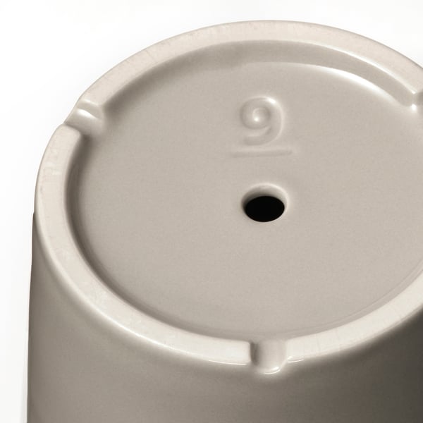 Close-up of modern white planter with drainage.