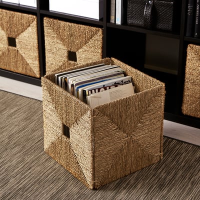 Woven seagrass basket on shelf holding magazines, part of KNIPSA series.