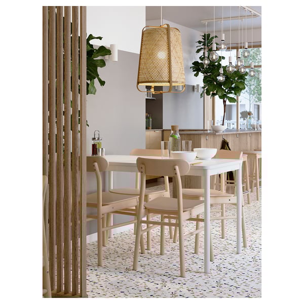 Modern dining room with white tables, KNIXHULT bamboo hanging lamps, and large windows.