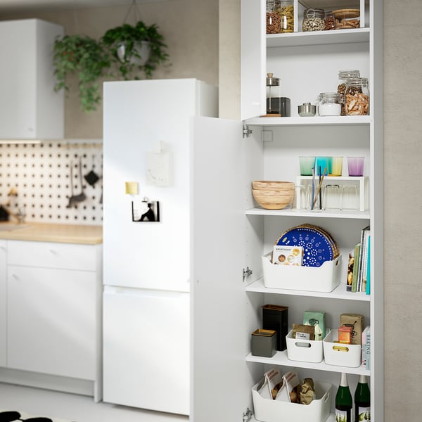 Open KNOXHULT kitchen cabinet with jars, bowls, and boxes.