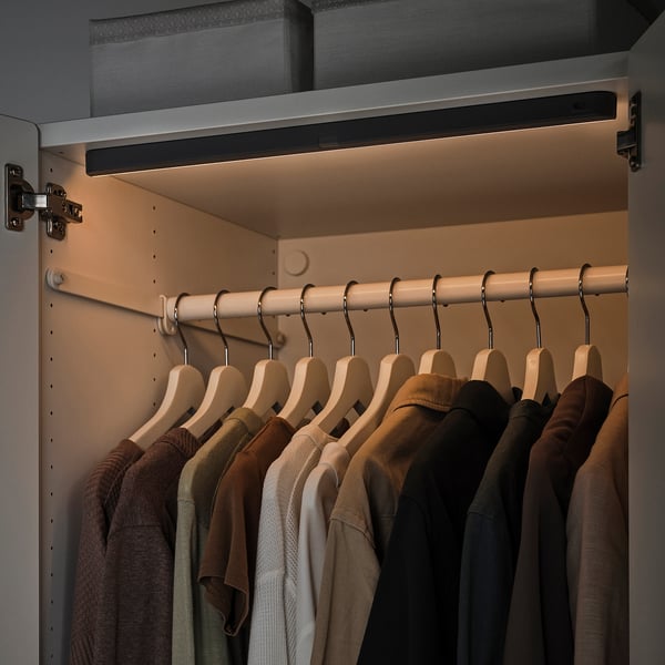 Closet with KÖLVATTEN led light, illuminating hangers and clothes.