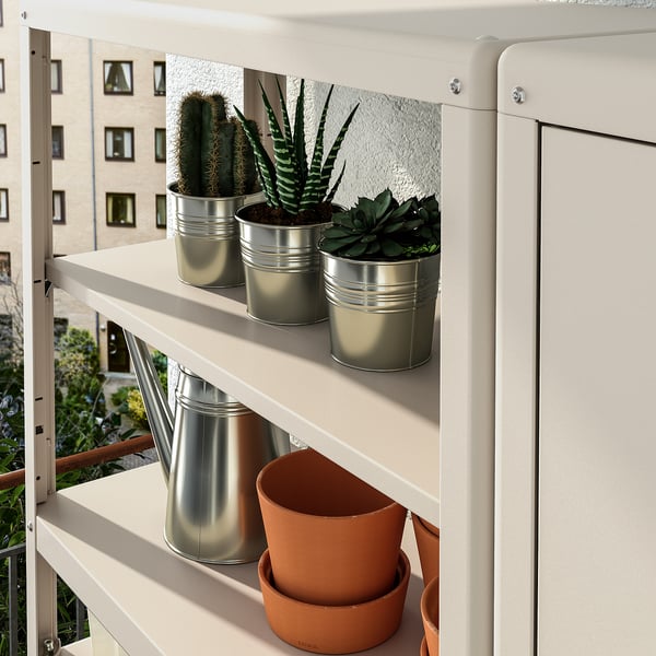 Shelf unit displaying metal pots with plants, ideal for outdoor storage.