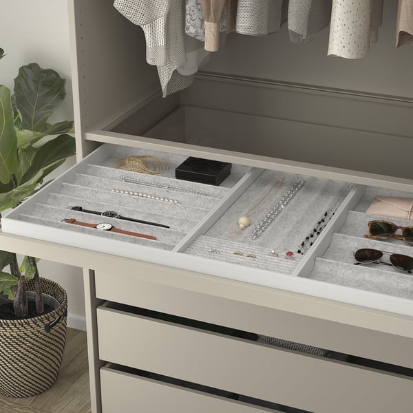 Organised jewellery tray with compartments for rings, necklaces, and watches. Soft felt protects items.