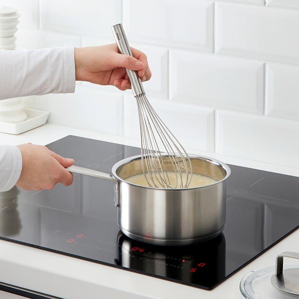 Whisking on modern stove with long handle.