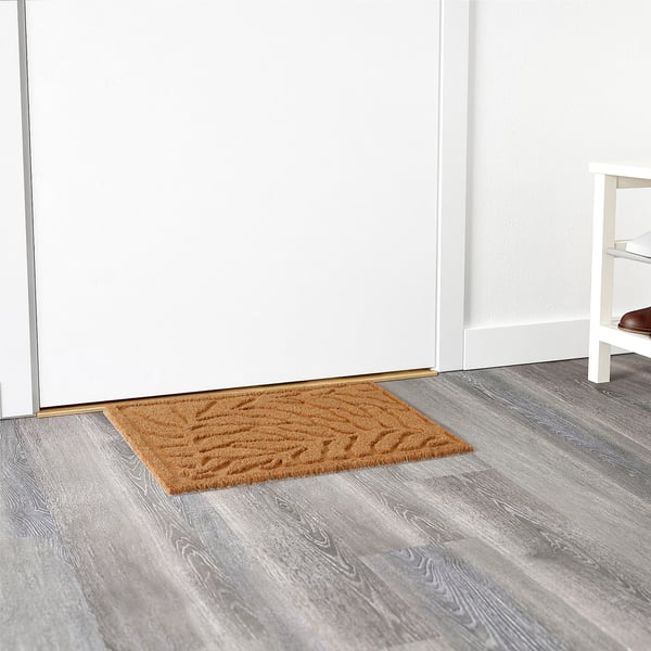 Doormat with raised leaf pattern at entryway, efficiently traps dirt.