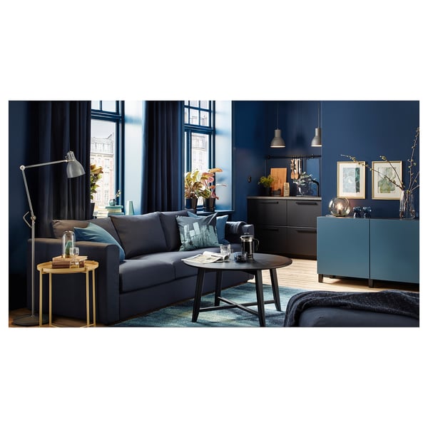 Stylish living room with KRAGSTA blue sideboard, grey sofa, and wooden coffee table. Dark blue walls, large windows, and pendant lights.