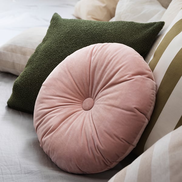 Autumnal cushions: green and pink velvet rounds with beige and white striped bedding.