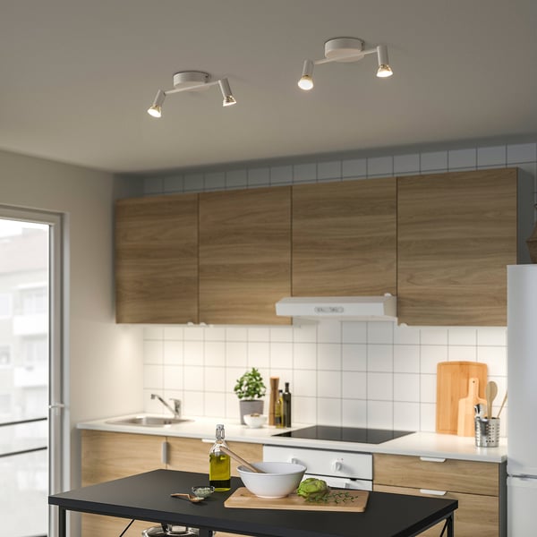 Modern kitchen with ceiling track lights over island, featuring adjustable spots and wooden cabinets.