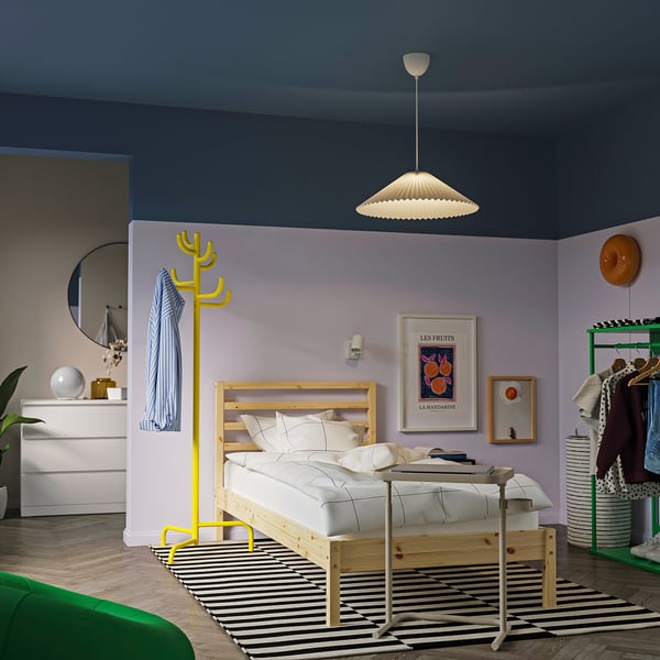 Yellow coat rack, wood bed, striped rug, colourful decor, blue walls.