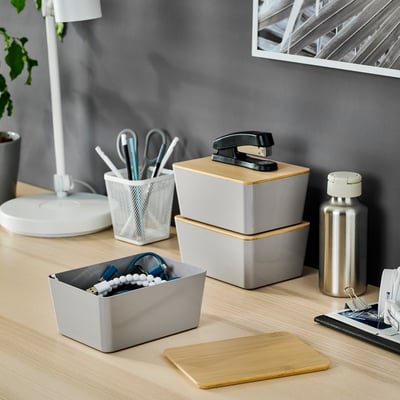 KUGGIS grey box stores blue/white office items, made from recycled plastic, blends with desk accessories.