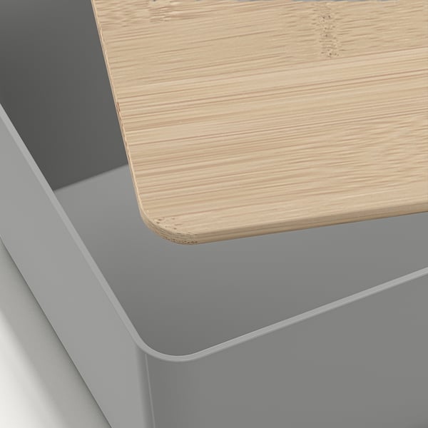 A close-up of a well-crafted storage box with a smooth bamboo lid and sleek grey plastic body, showing fine design and quality.