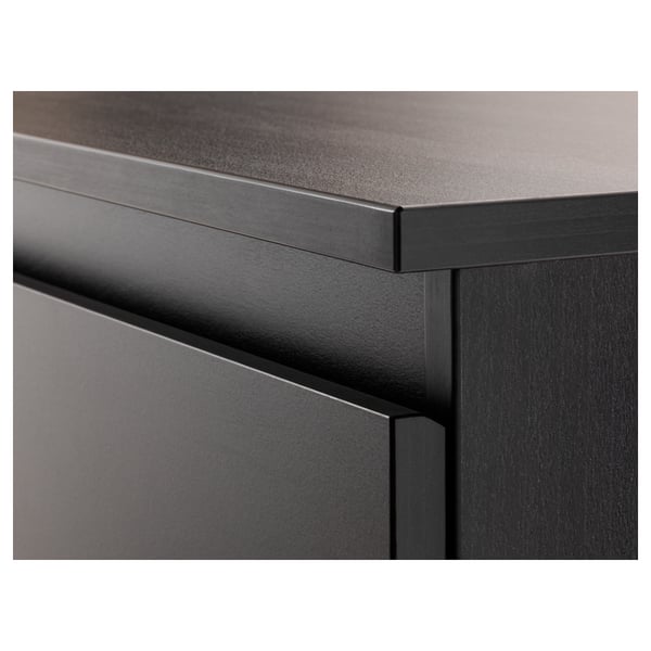 Close-up of modern drawer with sleek black finish. Detailed craftsmanship visible in edges and surfaces.