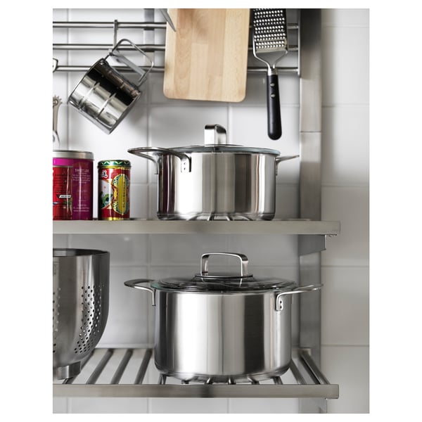 Stainless steel KUNGSFORS shelving system for pots and pans in a modern kitchen.