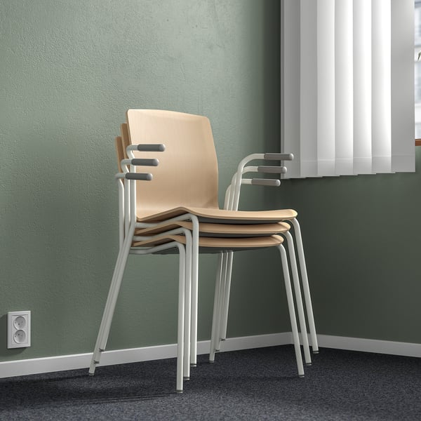 Three stacked chairs against green wall, light birch and gray legs.