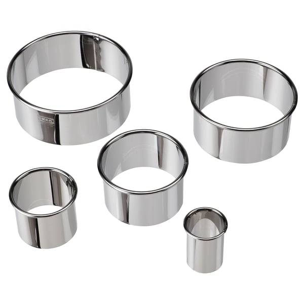 Five silver stainless steel round cookie cutters of varying sizes, neatly arranged in decreasing order of size.