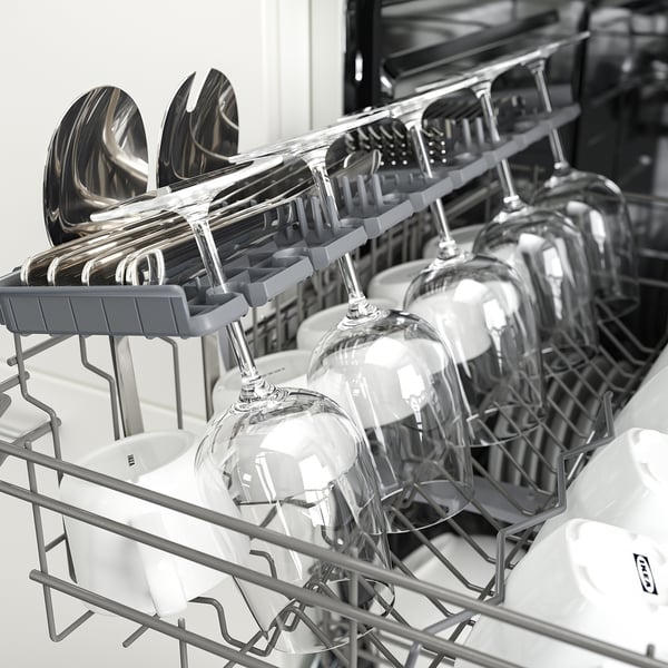 Black and white an open dishwasher, showing glasses and cutlery racks, illustrating a kitchen tool designed for dish cleaning.