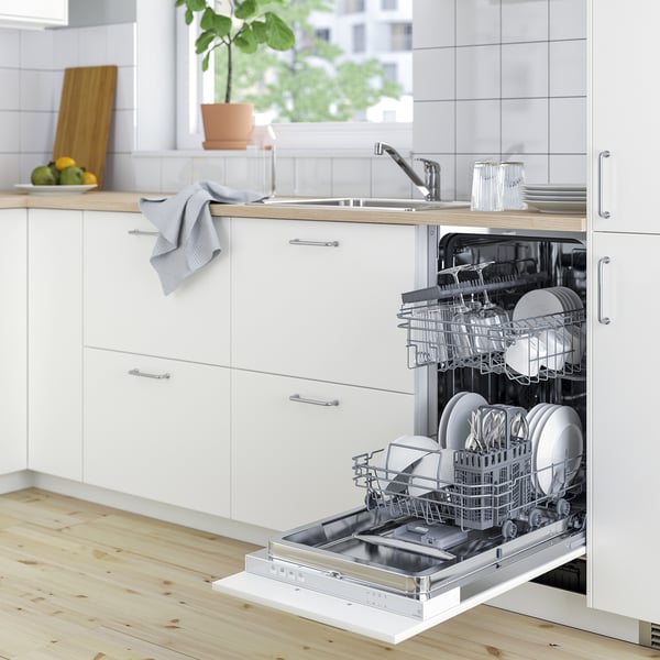 Small, white dishwasher with open door, displaying clean dishes, set in modern kitchen.