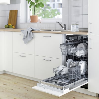 Small, white dishwasher with open door, displaying clean dishes, set in modern kitchen.
