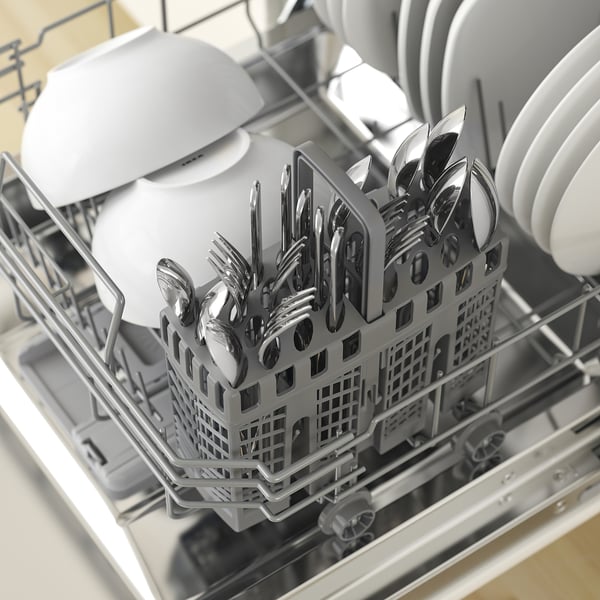 Open dishwasher with metallic cutlery tray filled with forks, knives, and spoons. Plates on top rack.