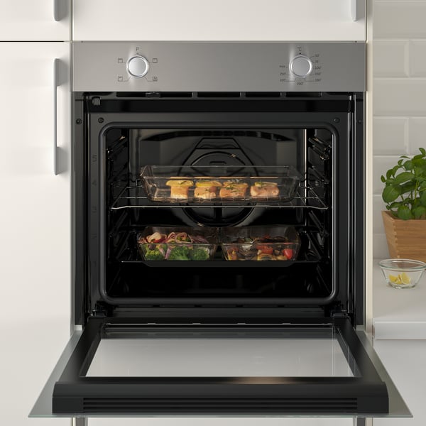 Built-in oven with top and bottom heating, cooking meals on two wire shelves.