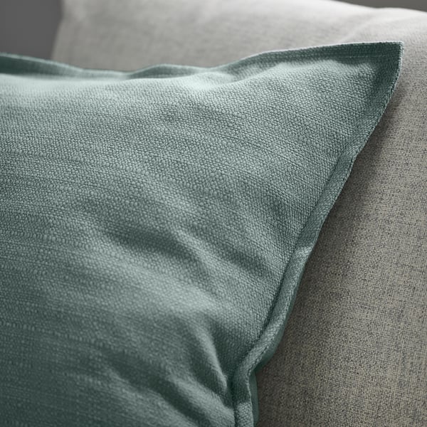 Close-up of a soft, textured cushion cover with flanged edging, intricate weave, and smooth zip.
