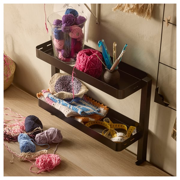 Craft station with crochet supplies: yarn, hooks, crochet hats, measuring tapes on LAGKAPTEN table.