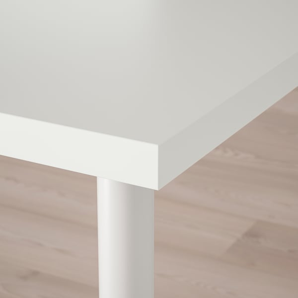 Close-up of modern, white tabletop with sleek edge and metal leg, showcasing clean design and sturdy support.