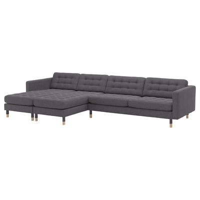 Modern, grey, l-shaped couch with tufted seats and wooden legs.