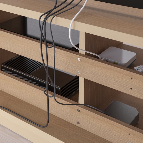 Wooden tv stand with glass doors, showing organised cables and media devices. Remote works through glass, with cable management for neat storage.