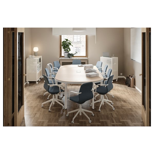 Modern office with circular table and 10 blue chairs. Well-lit room with wooden floors and white furniture.