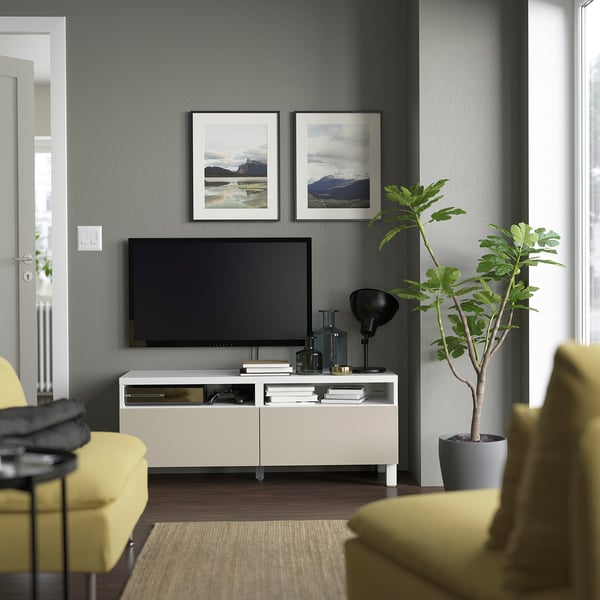 Modern living room with LAPPVIKEN console, tv, decor, and bright yellow chairs. Grey wall has nature photos, serene ambiance.