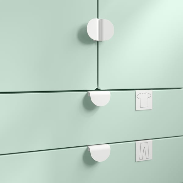 Three pastel green drawers with round pink handles and icons indicating shirt and pants.