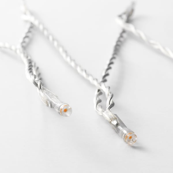 Two strings of led lights on white background, showcasing twisted cables and glowing bulbs.