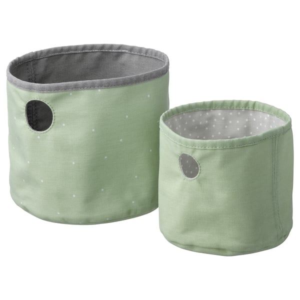 Two pastel green fabric storage bins, one larger, one smaller, with grey polka dot interiors and small handles.