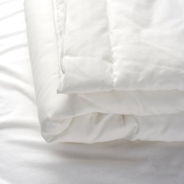 Close-up of a soft, high-quality white duvet with visible stitching, showcasing its plush texture and craftsmanship.