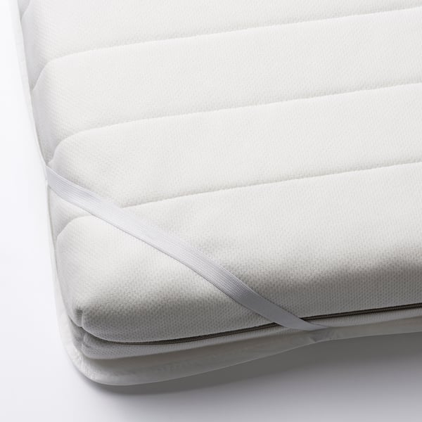 White mattress protector with elastic corners, folded, safeguards from accidents and spills.