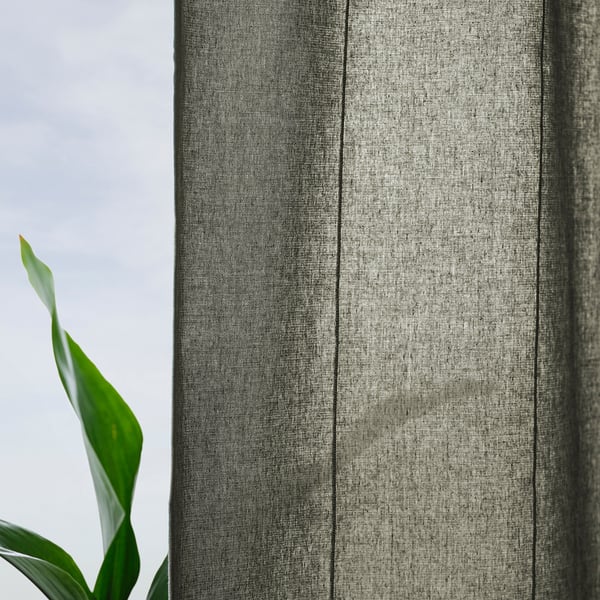 Green curtain reveals plant, header tape at top.