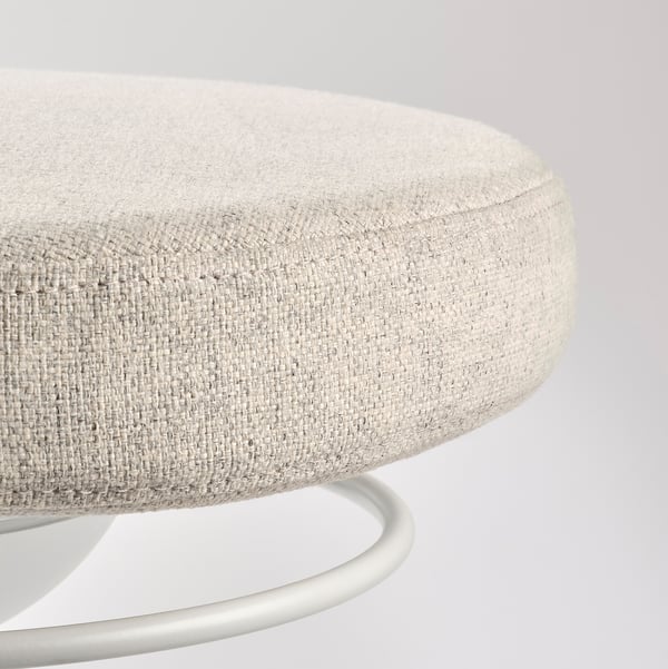 Round, light grey office chair with soft, textured fabric and metallic base, designed for comfort and support.