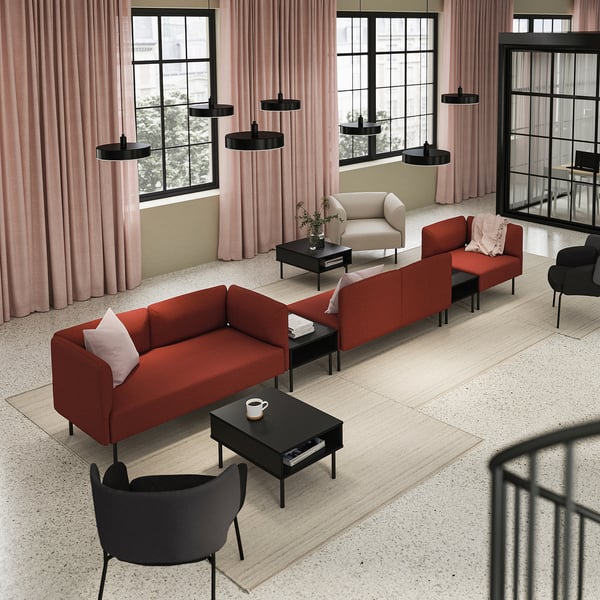 Modern living room with red LILLEHEM sofa, black coffee tables, pink curtains, and black pendant lights.