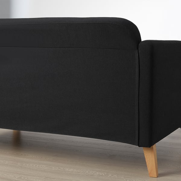 Black fabric sofa with wooden legs, modern & comfortable, reversible chaise.
