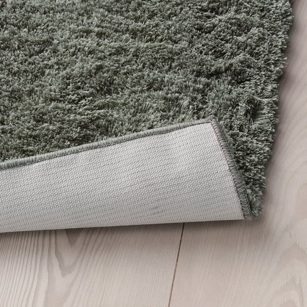 Grey plush rug on wooden floor, warm & soft for bedrooms.