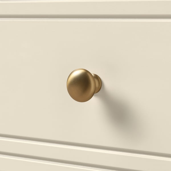 Branded gold knobs on a white cabinet, exuding elegance and durability, complementing a sleek, modern design.