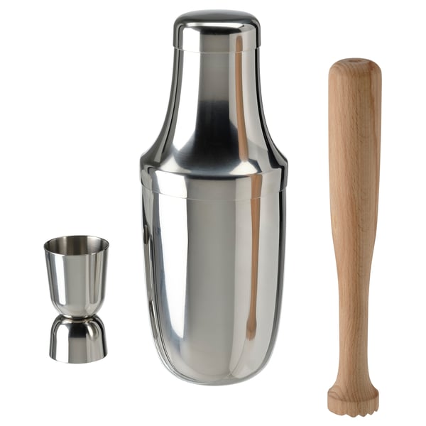 A LUFTTÄT cocktail set including a silver shaker, metal jigger, and wooden mortar. Perfect for mixing drinks, stylish and functional.