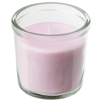 A light pink scented candle in a clear glass jar with a simple design.