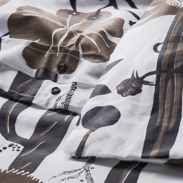 A white duvet cover with a wild botanical print, secured with plastic press-stud closure at the bottom.