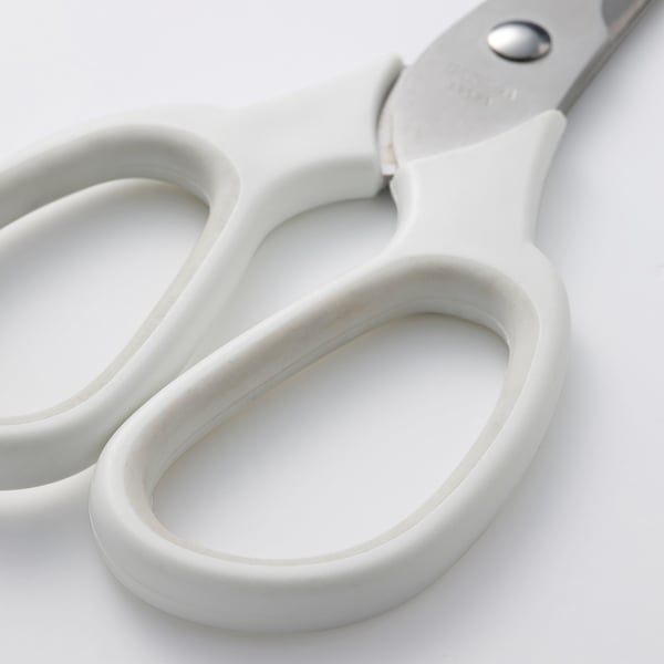 A pair of white-handled stainless steel scissors, designed for both right and left-handed use, resting on a white surface.