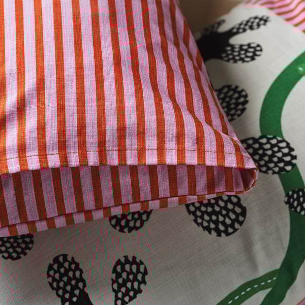 Striped cushion cover with black flower design, part of the MÄVINN collection.