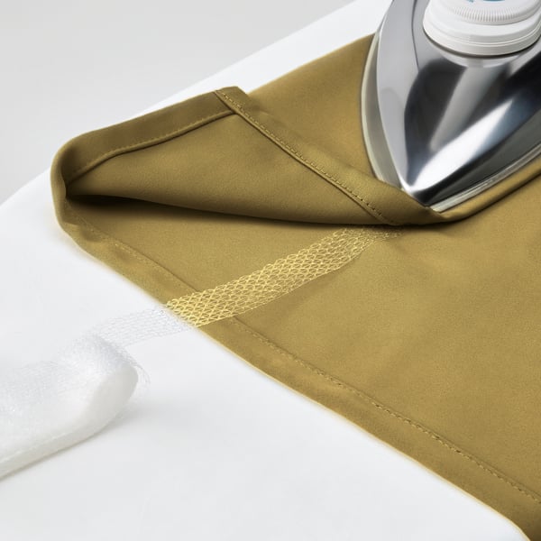 Olive curtain panel being ironed, ready for pleated hanging. Silver iron highlights fabrics softness, perfect for multi-use header.