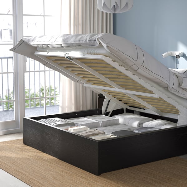 A modern bed with a lift-up base revealing storage space beneath, showcasing its functional design for efficient use of space.