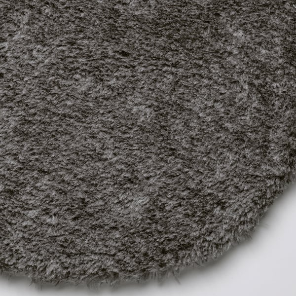 Close-up of soft, round, grey seating cushion. Fluffy texture, appears cosy and comfortable.